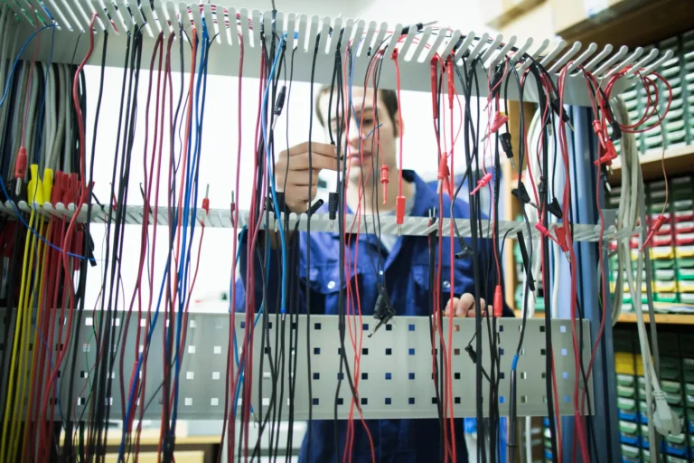 Technician working with multicolored electrical wires.